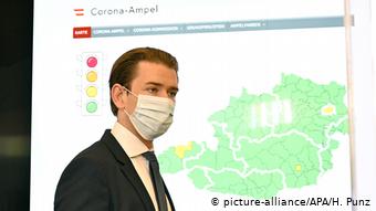 Канцлер Себастьян Курц на пресс-конференции перед картой Австрии с эпидемическими очагами
