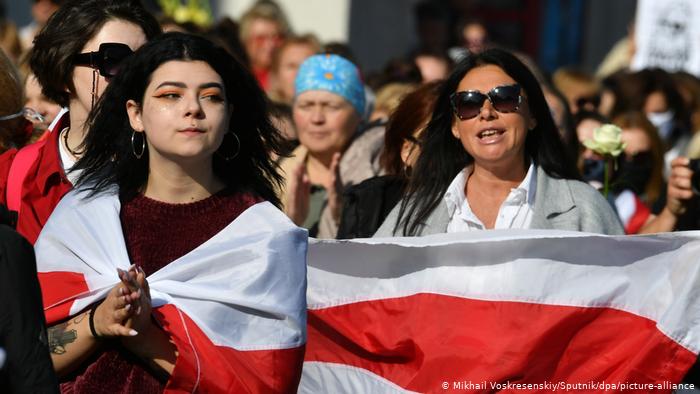 На одном из женских маршей - женщины с бело-красно-белыми флагами