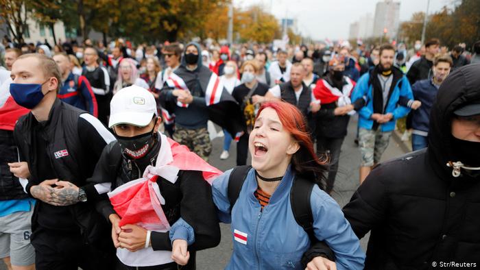 Колонна участников протеста с бело-красно-белыми флагами