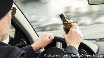 Человек с бутылкой пива за рулем 