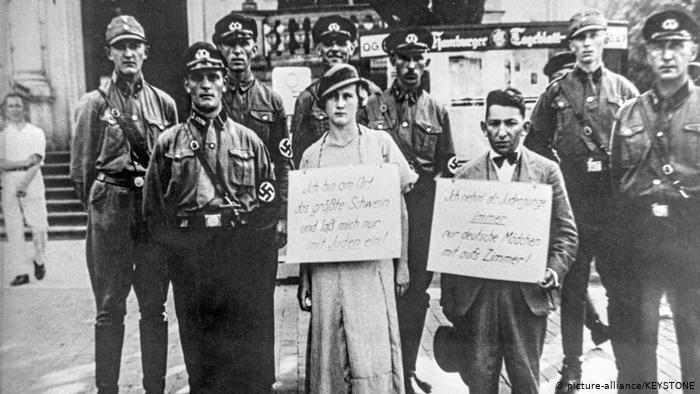 Ноябрь 1938. На одной из улиц Гамбурга нацисты выставили на всеобщий позор еврейскую девушку и еврейского юношу