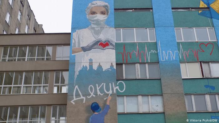 Граффити на фасаде больницы скорой помощи с изображением врача в защитной маске и словом Спасибо