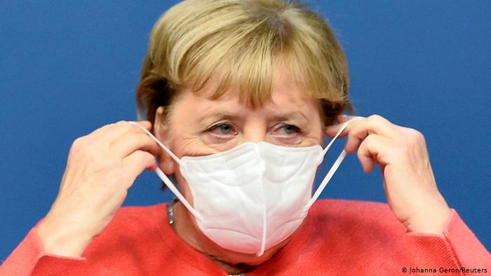 Ангела Меркель одевает защитную маску