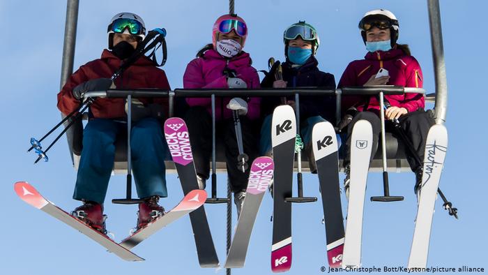 Лыжники в масках на подъемнике в Швейцарии