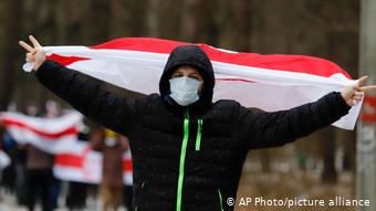 Белорусский участник акций протеста с бело-красно-белым флагом