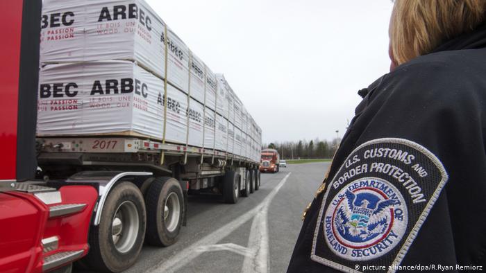 Тяжелый грузовик, груженый древесиной, пересекает границу США и Канады