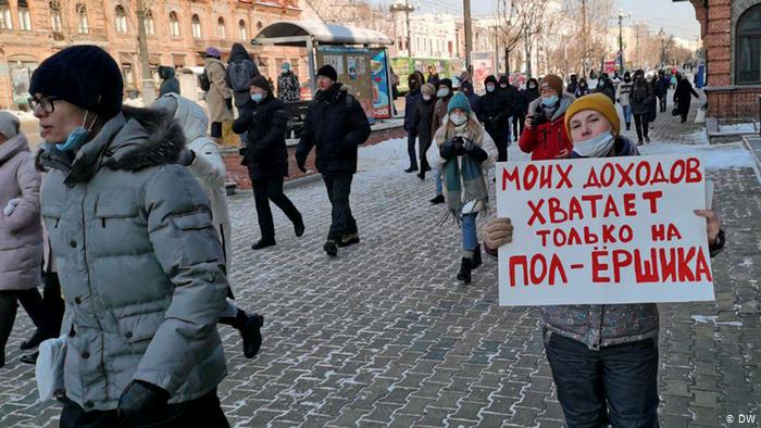 Люди с плакатами идут по одной из улиц Хабаровска