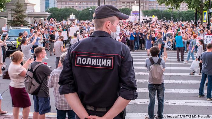 Сотрудник полиции наблюдает за шествием в поддержку бывшего губернатора Хабаровского края Сергея Фургала в Хабаровске, 21 июля 2020 года.