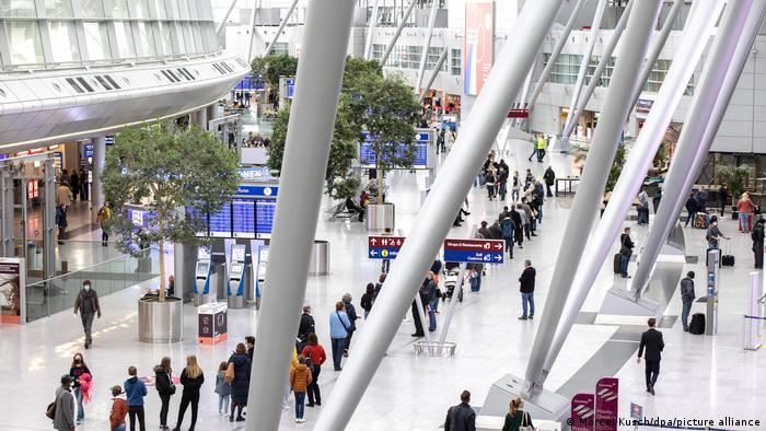 Авиапассажиры в аэропорту Дюссельдорфа стоят в очереди, чтобы сдать тест на коронавирус