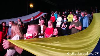 Зрители развернули украинский и белорусский бело-красно-белый флаги во время спектакля 