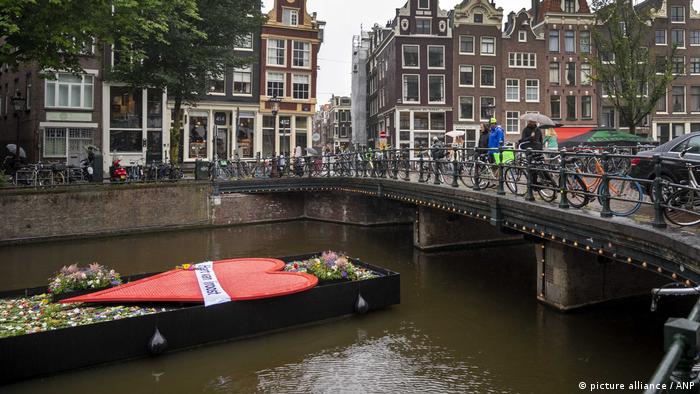 Лодка, украшенная цветами и свечами, в Амстердаме