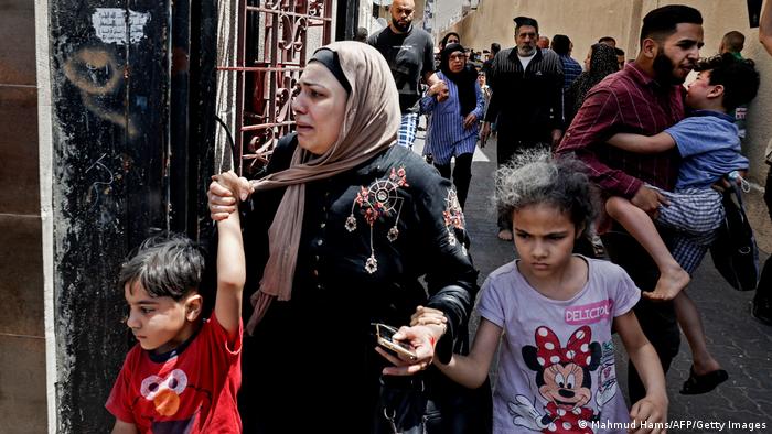 Женщины, дети и мужчины спасаются бегством. Город Газа в секторе Газа.