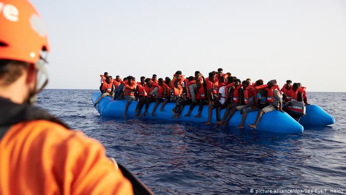 Спасение беженцев на надувной лодке в море 