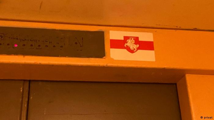 наклейка на входе в лифт - бело-красно-белый флаг 