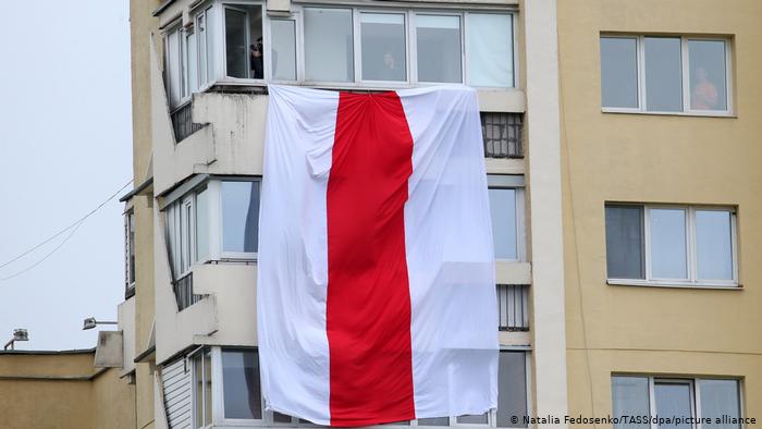 Бело-красно-белый флаг на балконе в многоэтажном доме