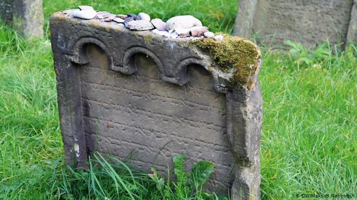 Старая надгробная плита с камнями и записками