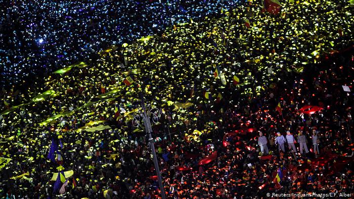 Гигантский румынский флаг, изображенный с помощью огней тысяч смартфонов, которые подсвечивают красные, синие и желтые полоски бумаги