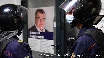 Сотрудники милиции на фоне плаката с портретом Виктора Бабарико