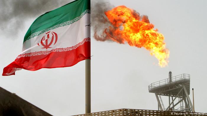 Иранский флаг на фоне нефтяной вышки