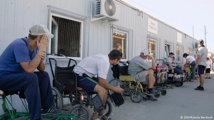 Станичные рикши за деньги подвозят людей к КПВВ на инвалидных колясках