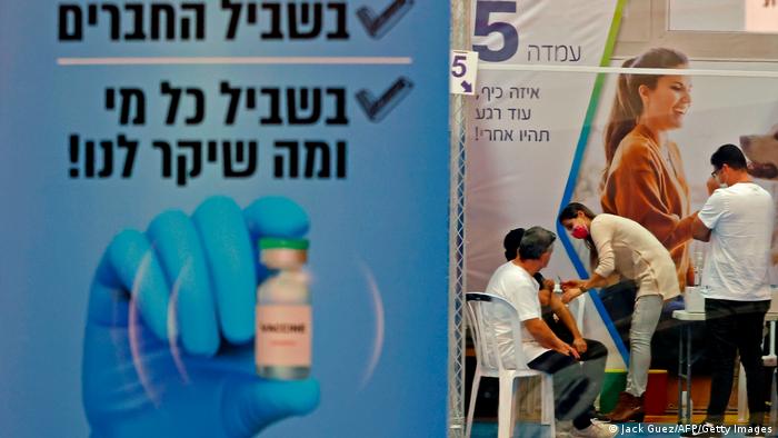 Плакат в одном из центров вакцинации в Израиле
