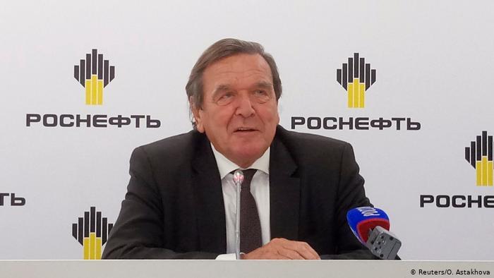 Герхард Шрёдер на фоне логотипа Роснефти