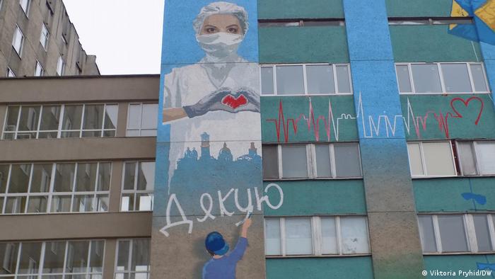 Граффити на фасаде больницы скорой помощи с изображением врача в защитной маске и словом Спасибо