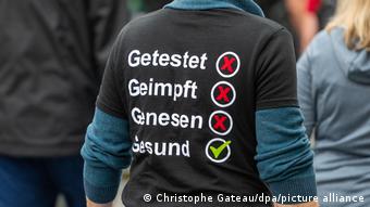 Участник демонстрации в Берлине, против правил, действующих в ФРГ во время пандемии. На майке надпись: протестирован, привит, переболел, здоров 