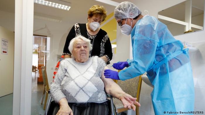 Пожилой немке делают прививку вакциной BioNTech и Pfizer
