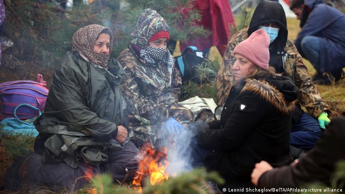 Женщины греются у костра на границе Беларуси и Польши 