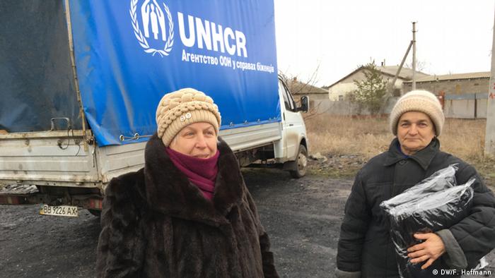 Сотрудники Управления ООН по делам беженцев раздают местному населению гуманитарную помощь