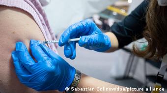 Во время вакцинации от коронавируса: медработник в перчатках делает прививку