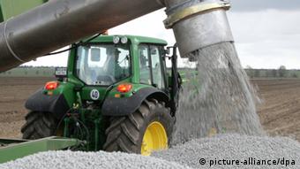 Трактор немецкого фермера разбрасывает удобрения 