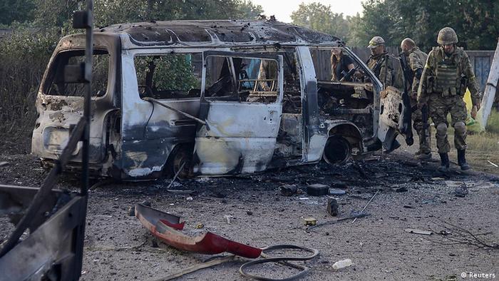 Украинские солдаты батальона Донбасс у сгоревшего автобуса