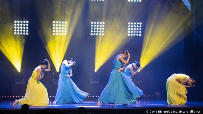 Танцовщицы в платьях цветов украинского флага на сцене в Монте-Карло, 16 апреля
