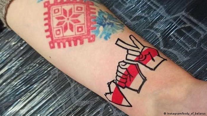 Рука з татуіроўкамі з сімваламі пратэсту 2020 года - сэрца, кулак і віктары