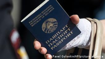 Женщина держит белорусский паспорт в посольстве Беларуси в Москве