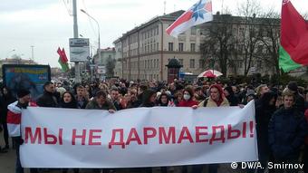 Участники акции протеста в Минске несут плакат Мы не дармоеды