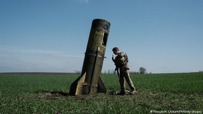 Украинский военный и остатки российской ракеты в селе Богодарово в Харьковской области