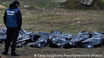 Следователь из международной команды криминалистов осматривает тела мирных жителей, убитых в Буче