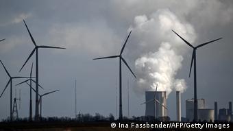 Ветряки на фоне угольной электростанции в Германии