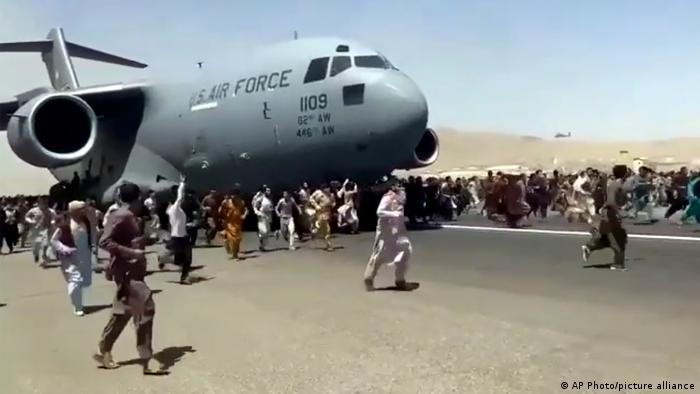 Афганцы бегут рядом с американским самолетом, вылетающим из Кабула, август 2021 года
