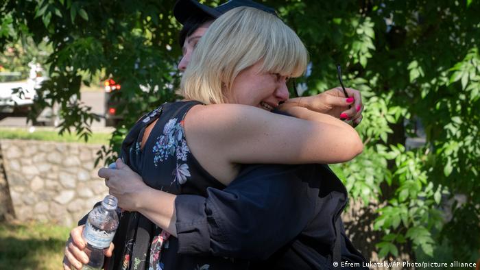 Плачущие близкие погибших в Кременчуге