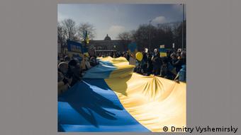 Демонстранты держат огромный желто-голубой флаг Украины. Фотография Дмитрия Вышемирского