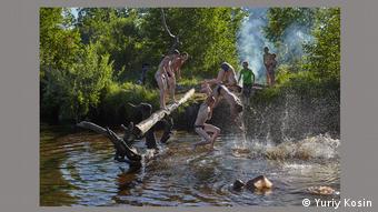 Мальчики прыгают в реку со ствола упавшего в воду дерева. Фотография Юрия Косина